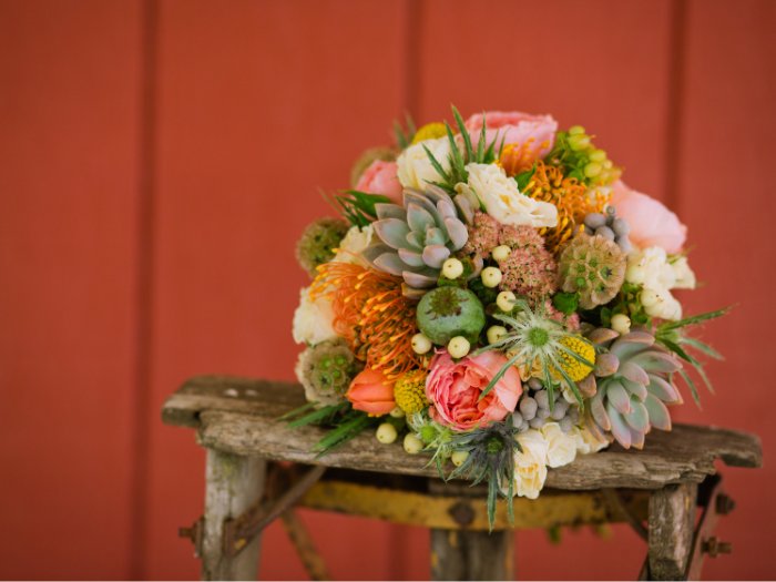 A whimsical and vibrant wedding bouquet with a mix of succulents, daisies, and greenery, perfect for a boho-inspired celebration