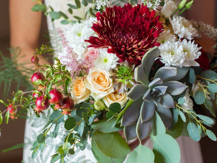 Elegant and unique, this succulent wedding bouquet features vibrant greenery and delicate white blooms for a fresh, natural look